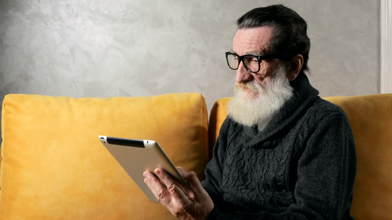 Stock Video Old Man Answers Mobile Phone Call While On Tablet At Live Wallpaper