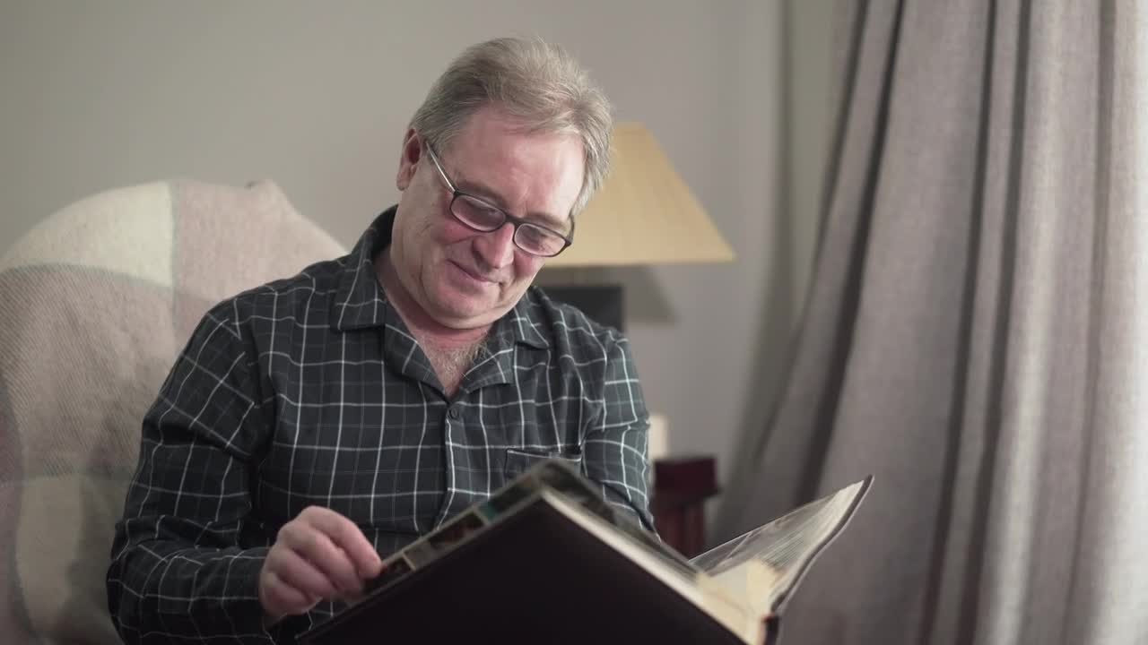 Stock Video Old Man Remembering With His Photo Album Live Wallpaper
