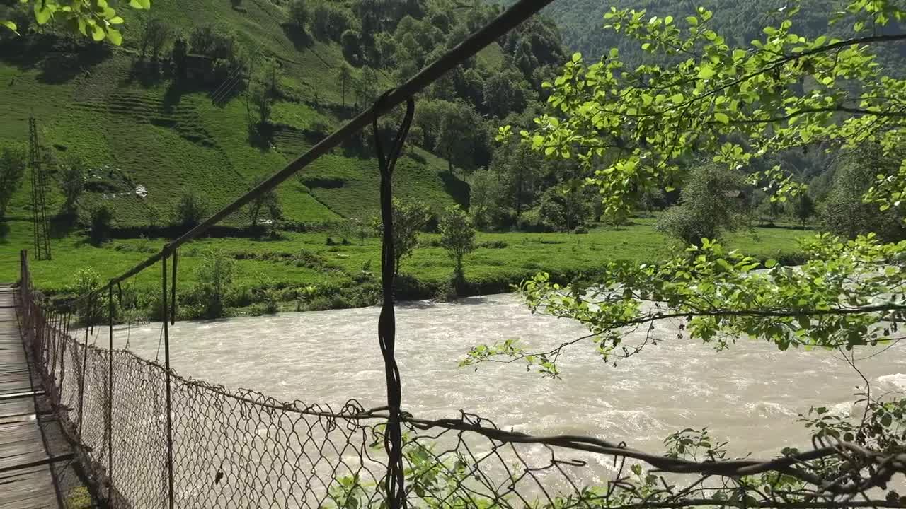 Stock Video Old Suspended Wooden Bridge Over A River Live Wallpaper