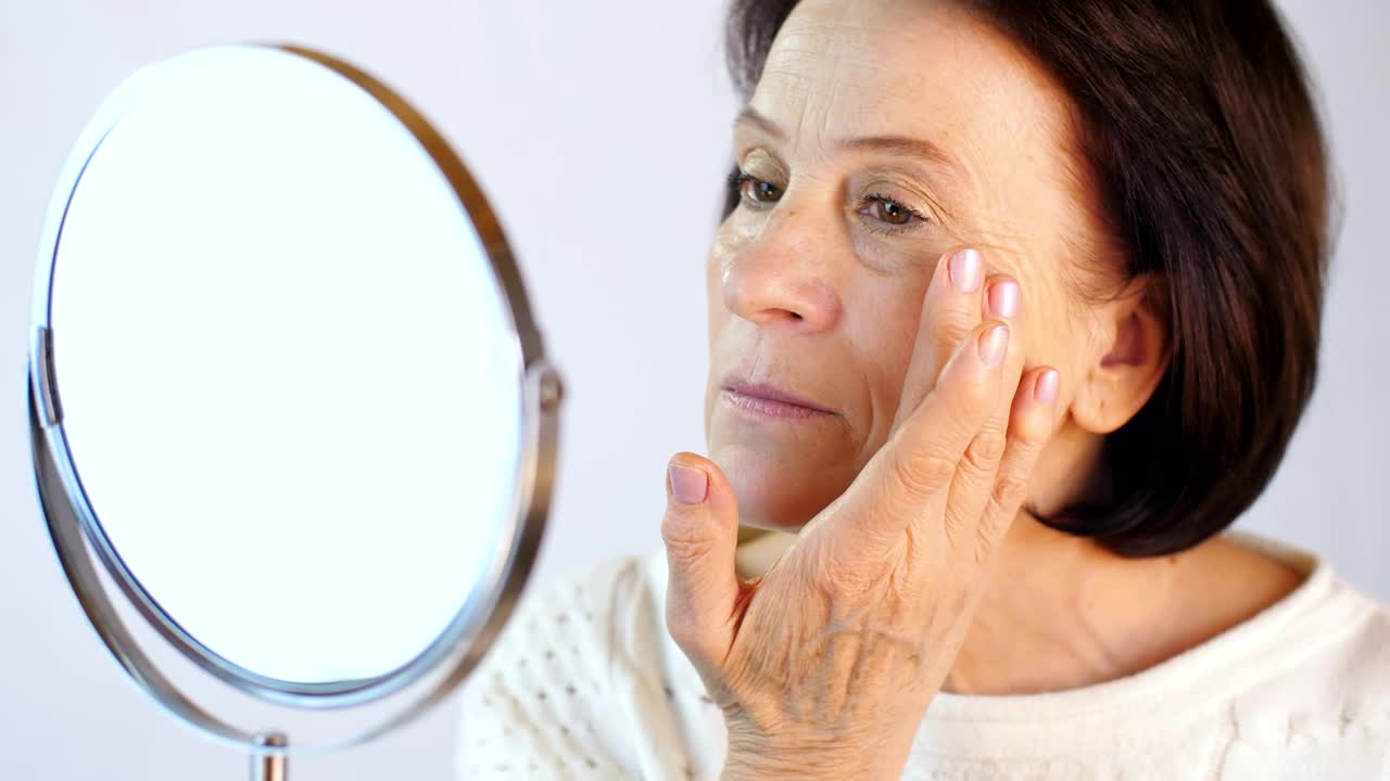 Stock Video Old Woman Happily Looking Her Face In A Mirror Live Wallpaper