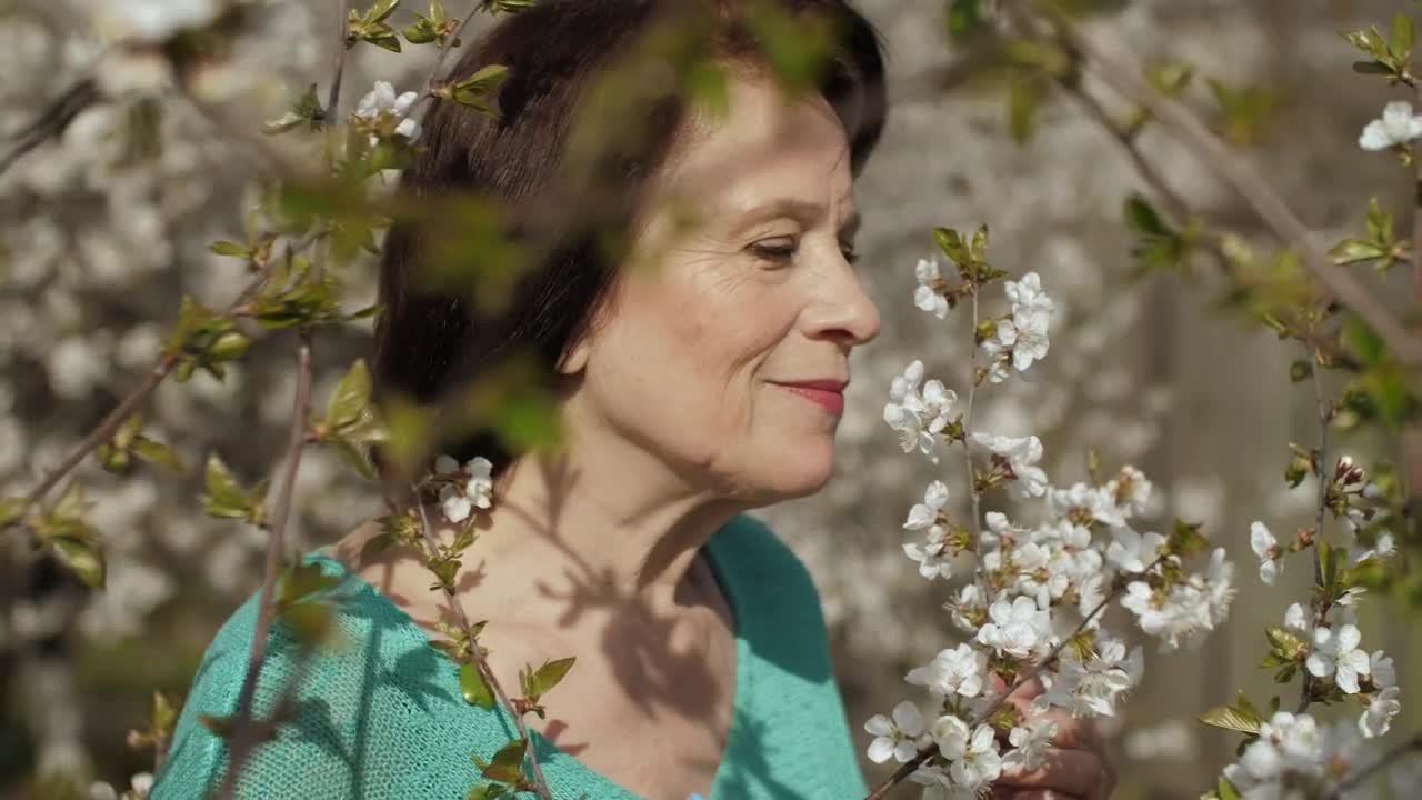 Stock Video Old Woman Smelling Flowers From Her Garden Live Wallpaper