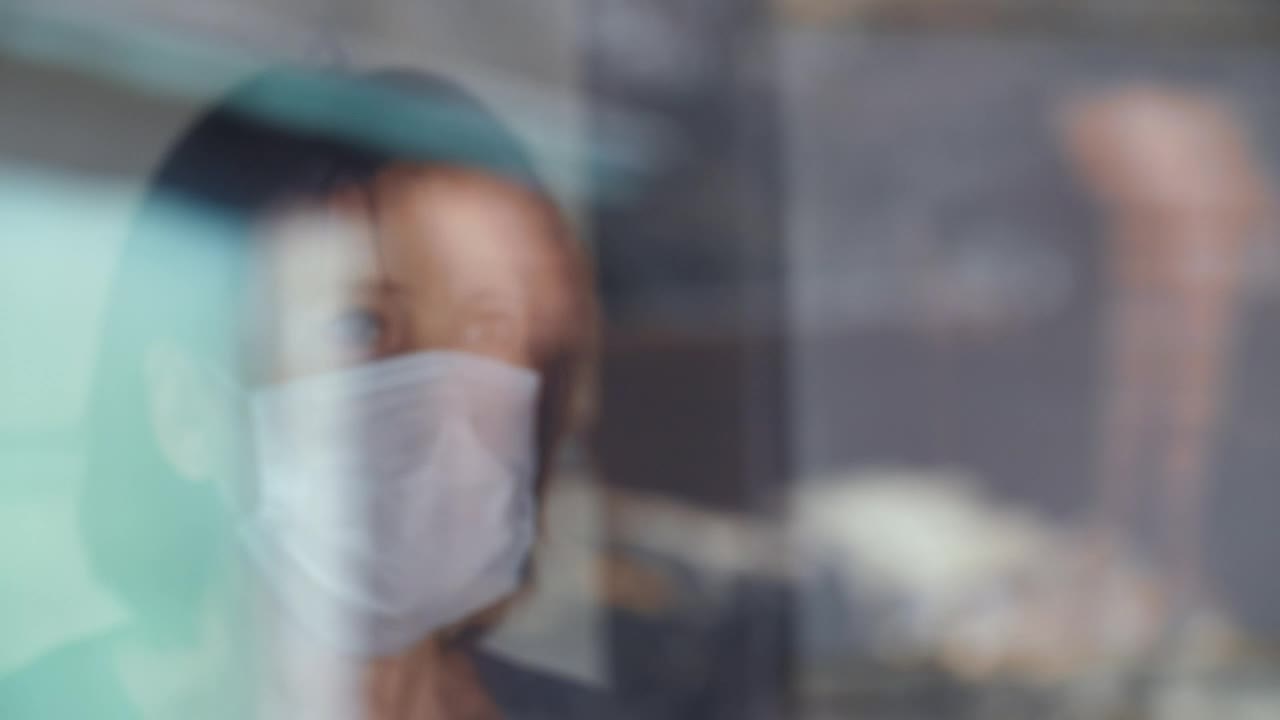 Stock Video Old Woman With Mask Looks Out The Window Live Wallpaper
