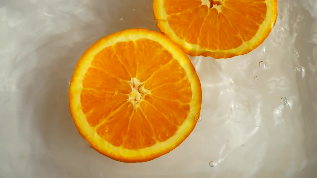 Stock Video Orange Half Spinning While Floating In Water Live Wallpaper