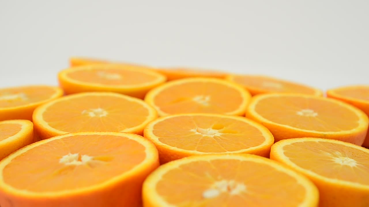 Stock Video Orange Halves Spinning With A White Background Live Wallpaper