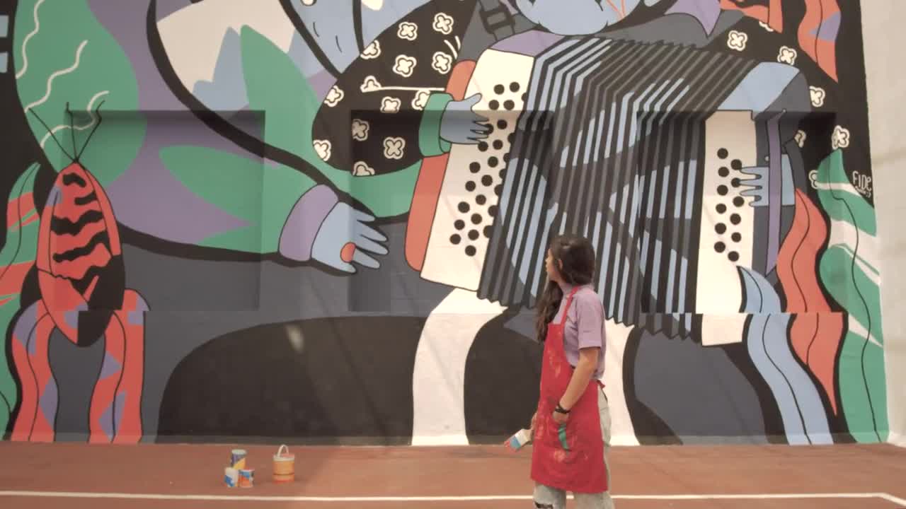 Stock Video Paint Covered Woman Stands In Front Of Mural Live Wallpaper