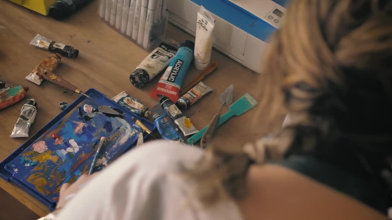Stock Video Painter Working On An Artwork In Her Home Studio With Live Wallpaper