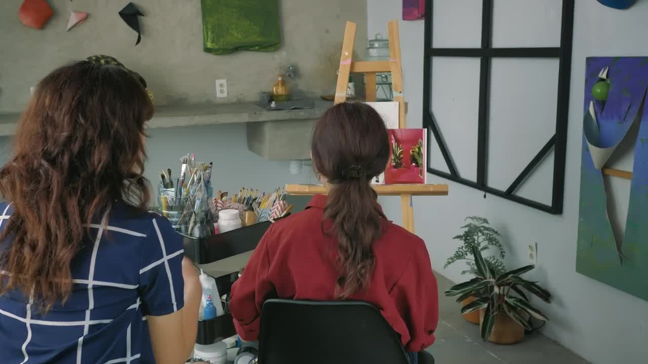 Stock Video Pair Of Artist Girls Working Together On A Painting Live Wallpaper