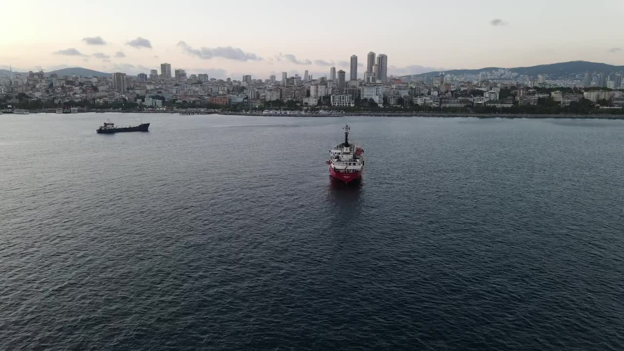 Stock Video Pair Of Cargo Ships Sailing Near A Coastal Town Live Wallpaper