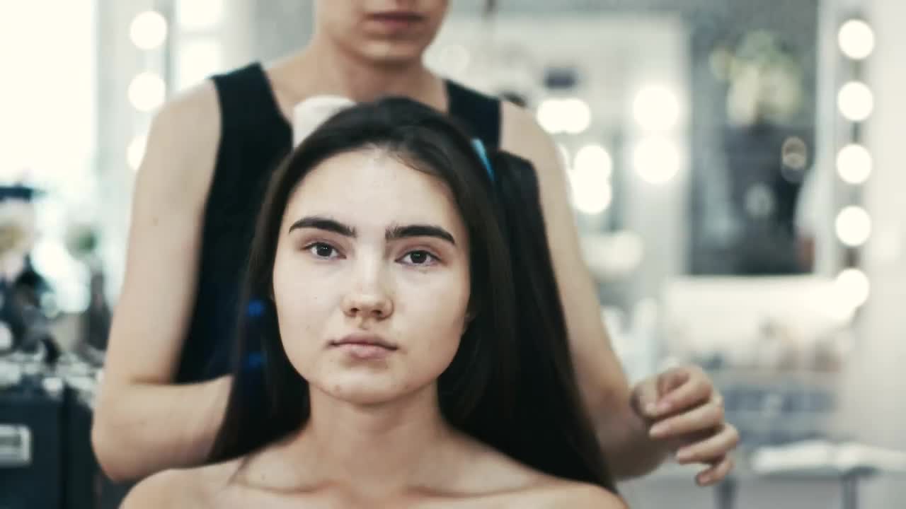 Stock Video Pair Of Makeup Artists Working On A Young Woman Live Wallpaper