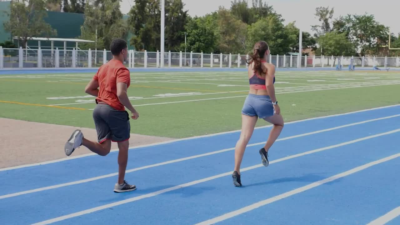 Stock Video Pair Of Man And Woman Athletes Running On A Track Live Wallpaper