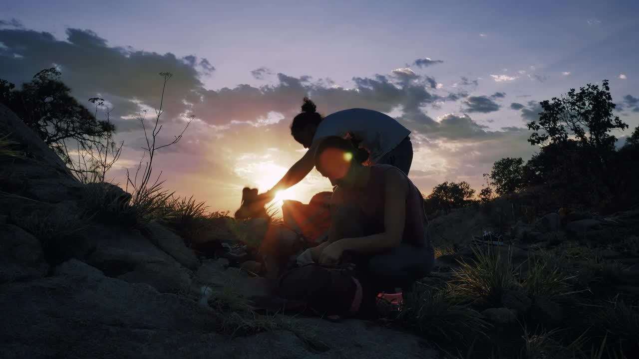Stock Video Pair Of Mountaineers Putting Away Their Things At Sunset Live Wallpaper