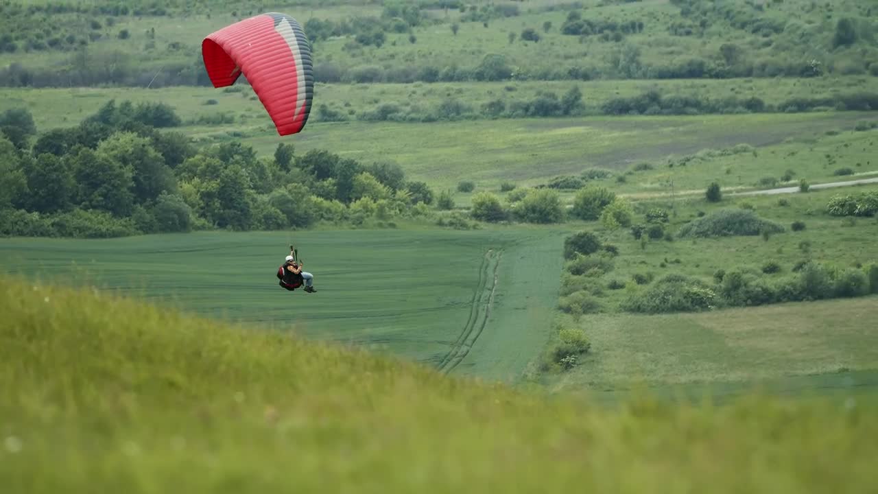 Stock Video Paraglider Floats Over Green Countryside Live Wallpaper
