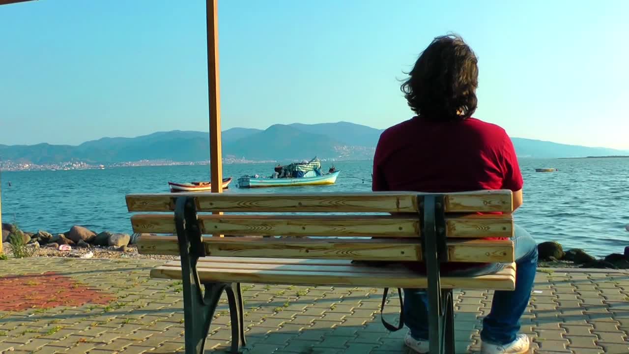Stock Video Pensive Man Looks At The Sea From A Bench Live Wallpaper