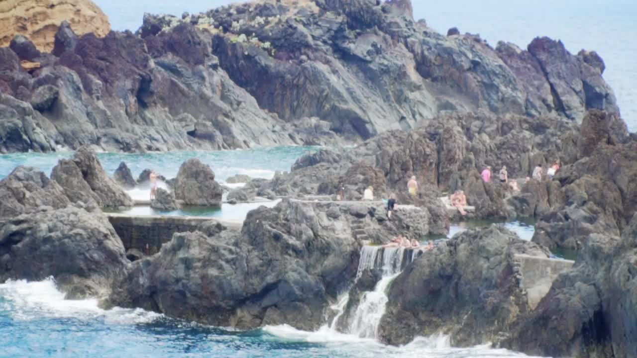 Stock Video People Bathing On The Rocks Of The Seashore Live Wallpaper
