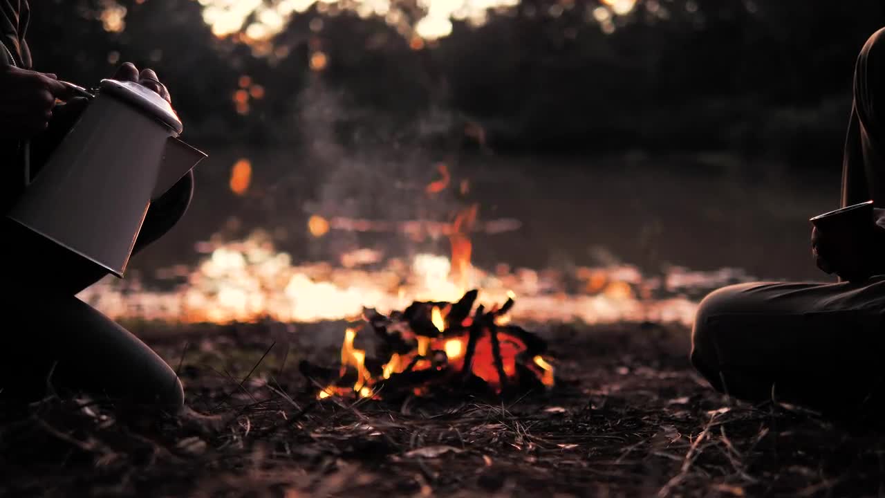 Stock Video People Pouring A Warm Drink Around A Campfire Live Wallpaper