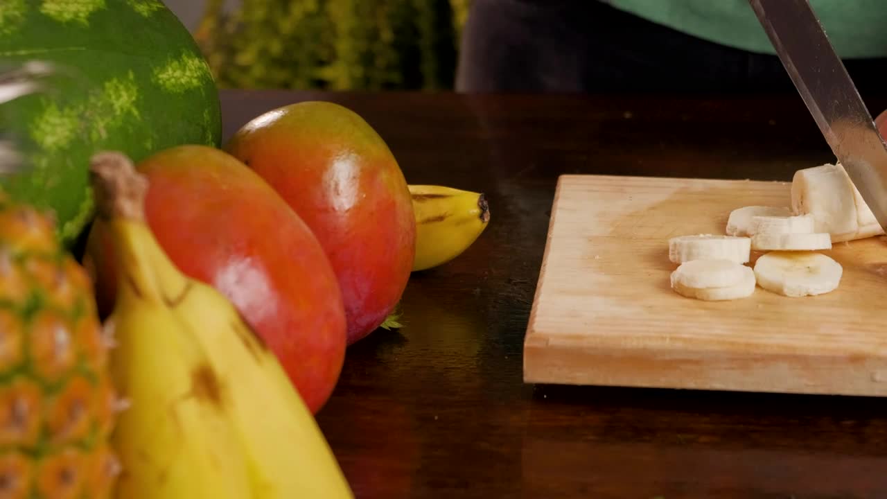 Stock Video Person Cutting Banana For A Fruit Cocktail Live Wallpaper