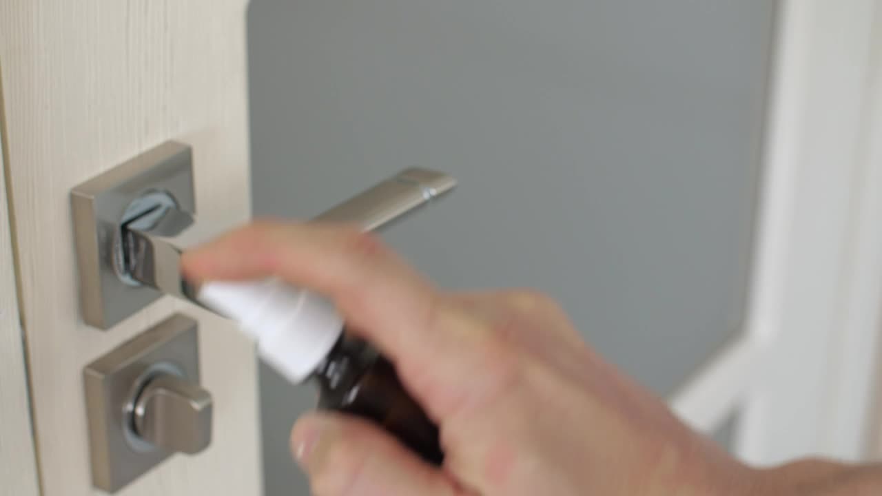 Stock Video Person Disinfecting A Door With Spray Live Wallpaper