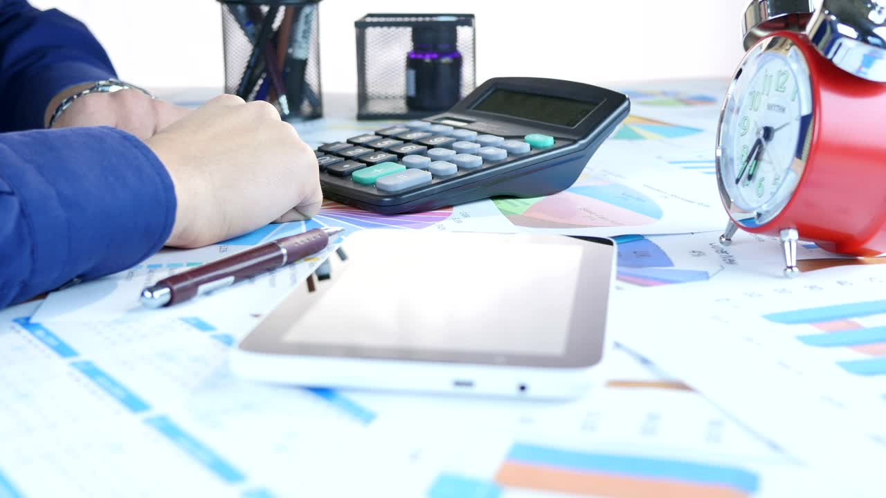 Stock Video Person Doing Accounts And Graphs On A Table Live Wallpaper
