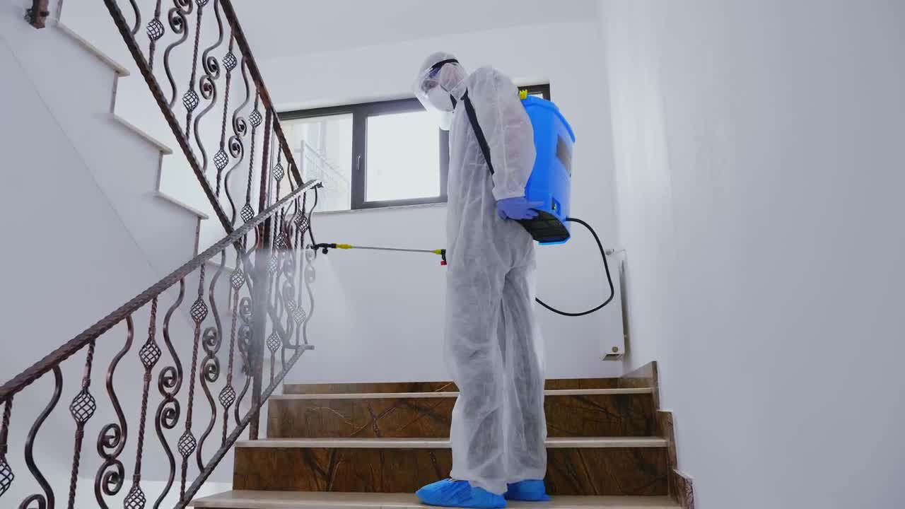 Stock Video Person In Ppe Sanitizing Building During Pandemic Live Wallpaper