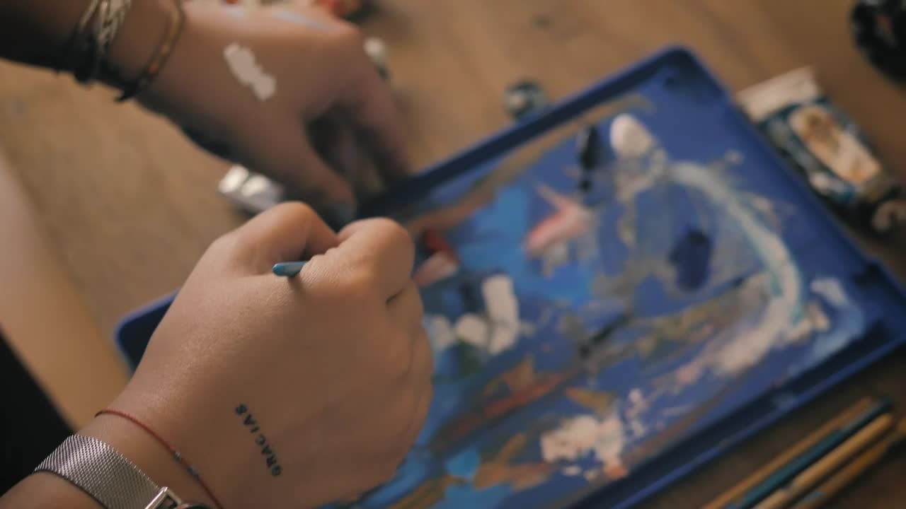 Stock Video Person Mixing Paint On A Table Live Wallpaper