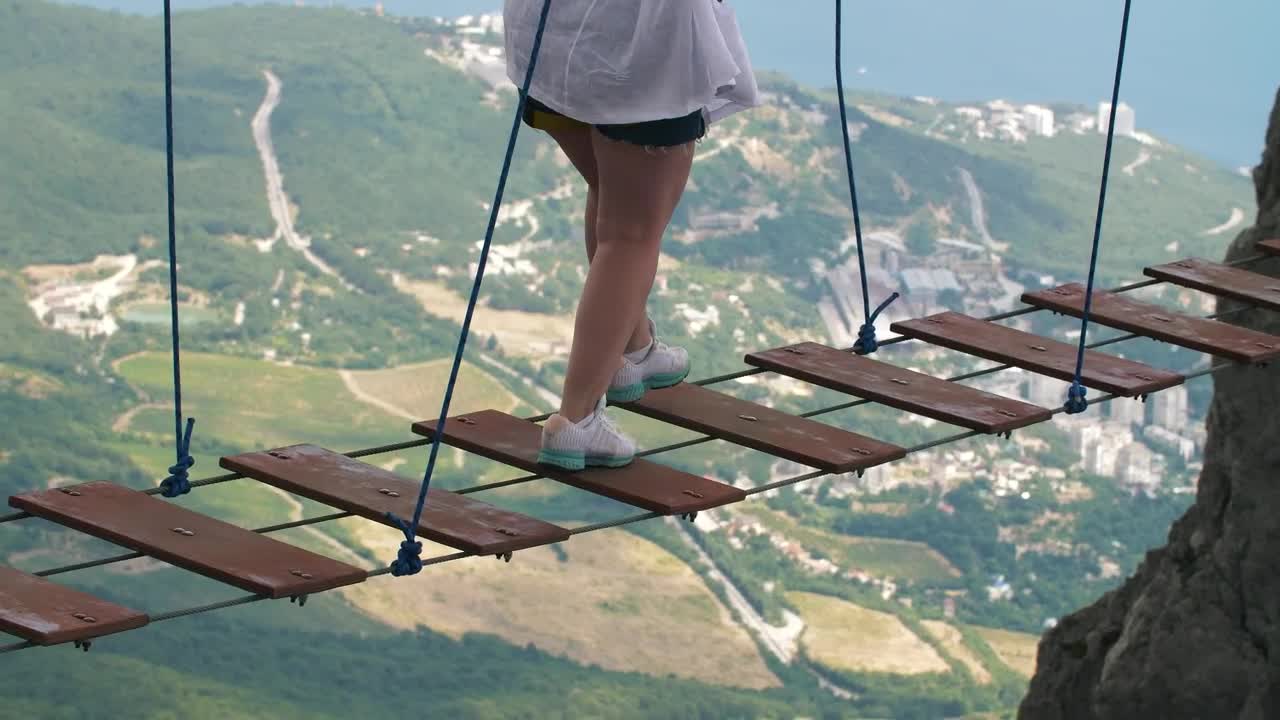 Stock Video Person On A Suspension Bridge Between Mountains Live Wallpaper