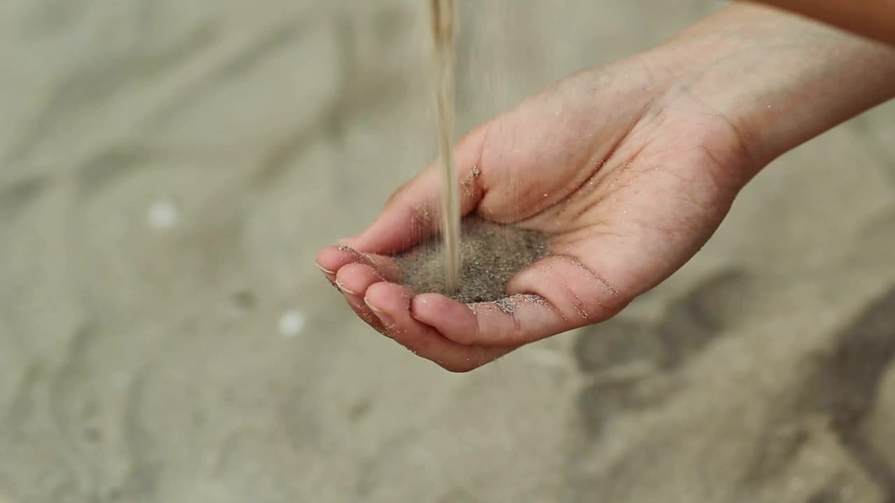 Stock Video Person Passing Sand From One Hand To Another Live Wallpaper