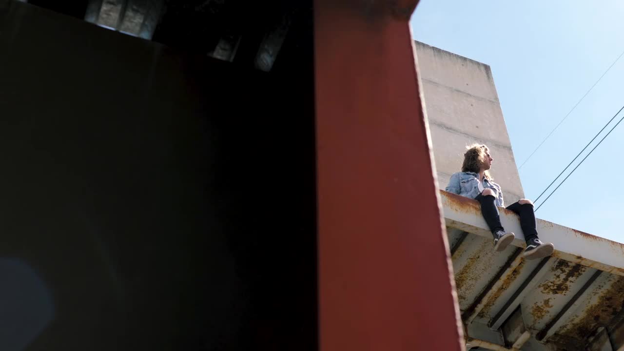 Video Stock Person Sits On Awning Of Abandoned Building Live Wallpaper Free