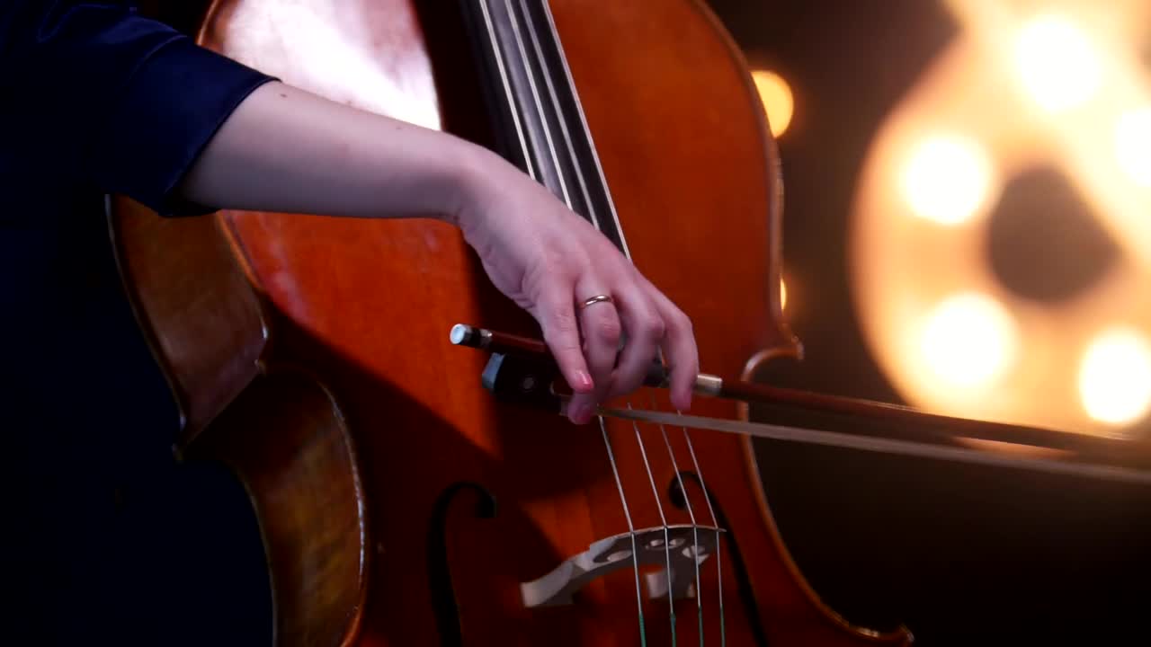 Video Stock Playing The Cello With Blurry Lights In The Background Live Wallpaper Free