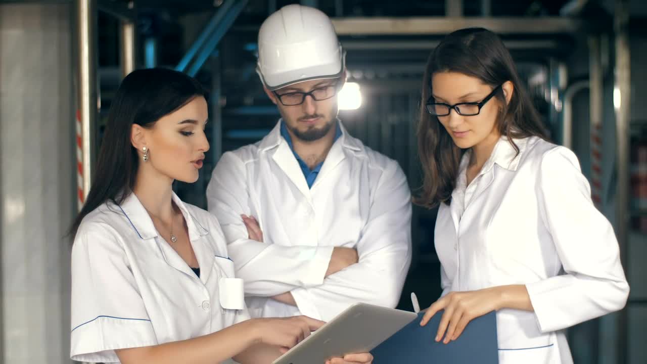 Video Stock Quality Inspectors Reviewing Reports On A Tablet Live Wallpaper Free