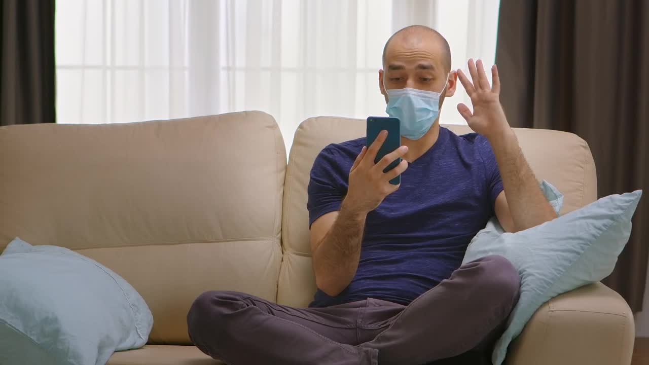 Video Stock Quarantined Man Chats On Smartphone On Couch Live Wallpaper Free