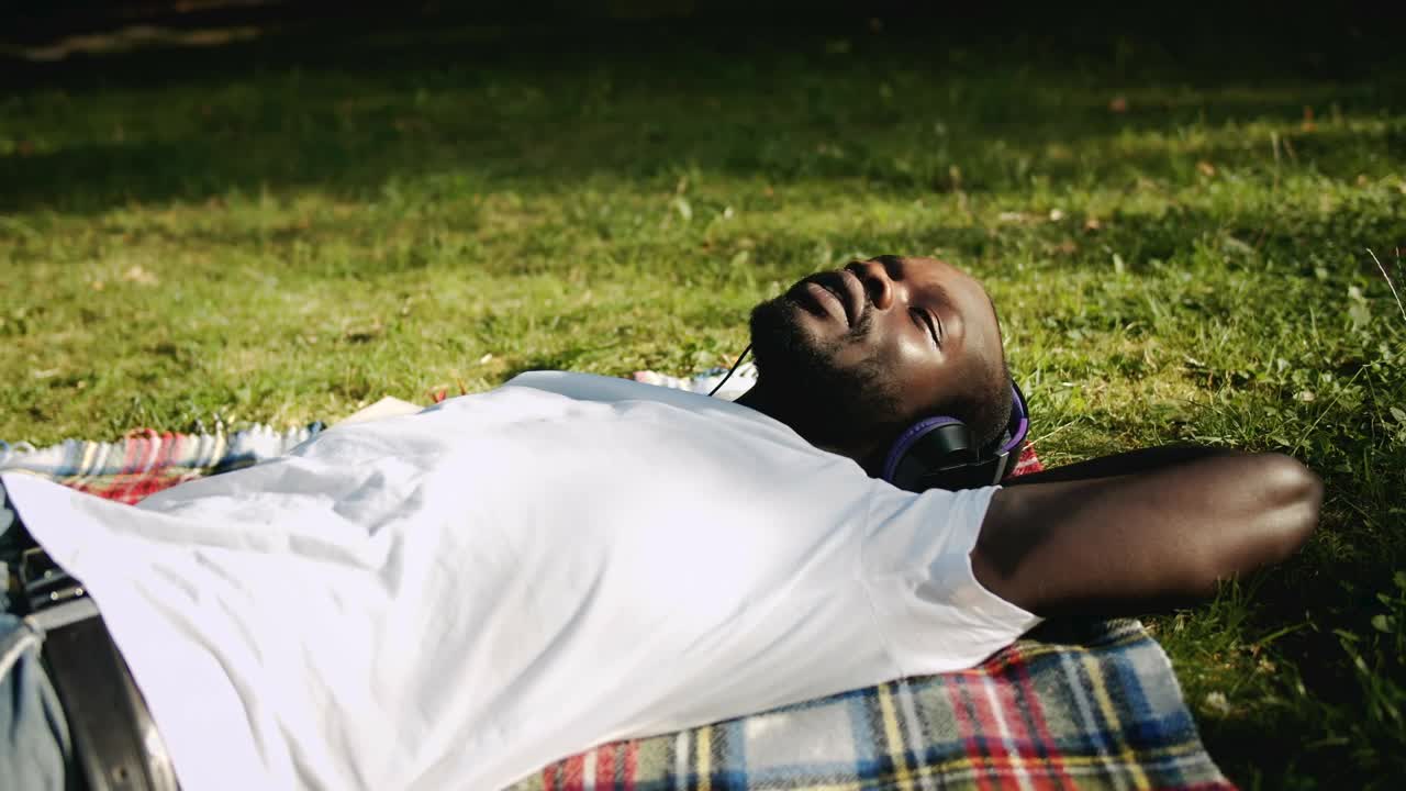 Free Stock Video Relaxed Man Enjoys Music While Lying On Grass Live Wallpaper