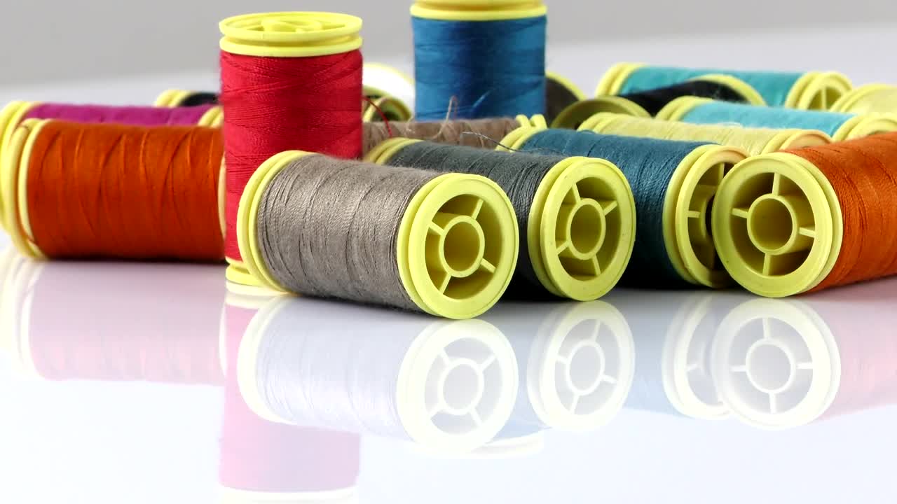 Free Stock Video Rolls Of Thread On A Reflective White Table Live Wallpaper