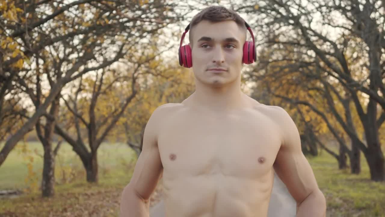 Free Stock Video Shirtless Man In Headphones Flexes Muscles Before Outdoor Workout Live Wallpaper