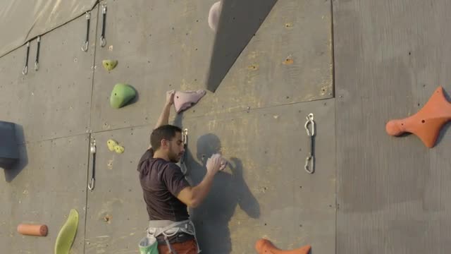 Free Video Stock Skillfully Climbing To The Top Of A Large Mountaineering Wall Live Wallpaper