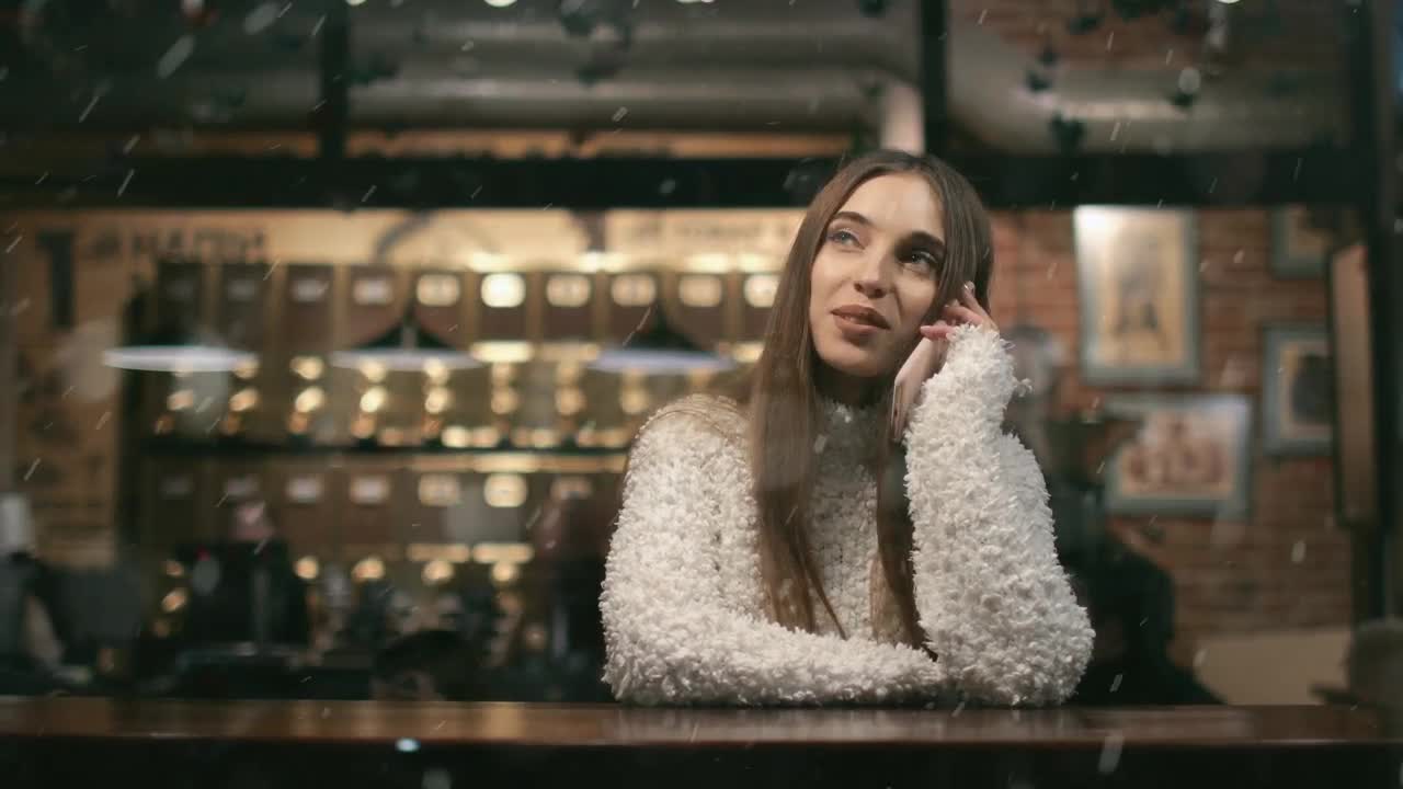 Free Video Stock Smiling Woman Watches Snowfall While On Mobile In Cafe Live Wallpaper