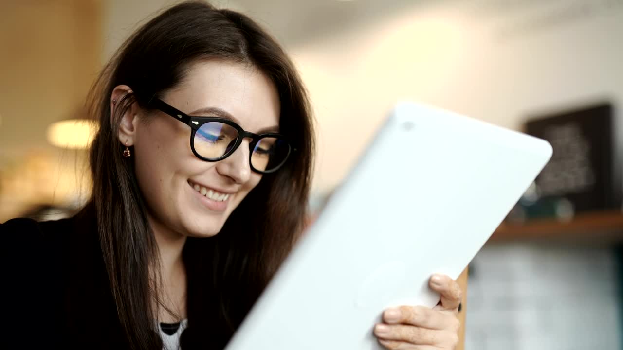 Free Video Stock Smiling Young Woman Surfs Internet On Tablet Live Wallpaper