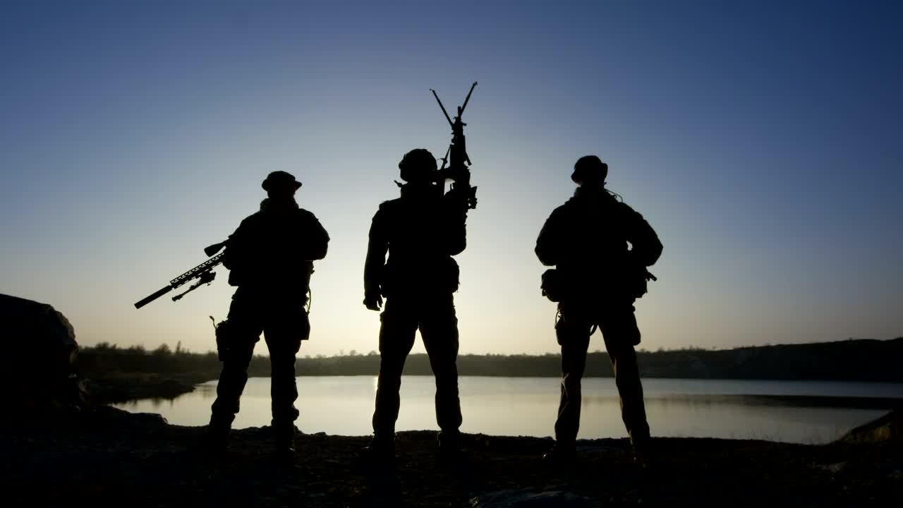 Free Video Stock Soldier Silhouettes Posing With Guns In The Sunset Live Wallpaper
