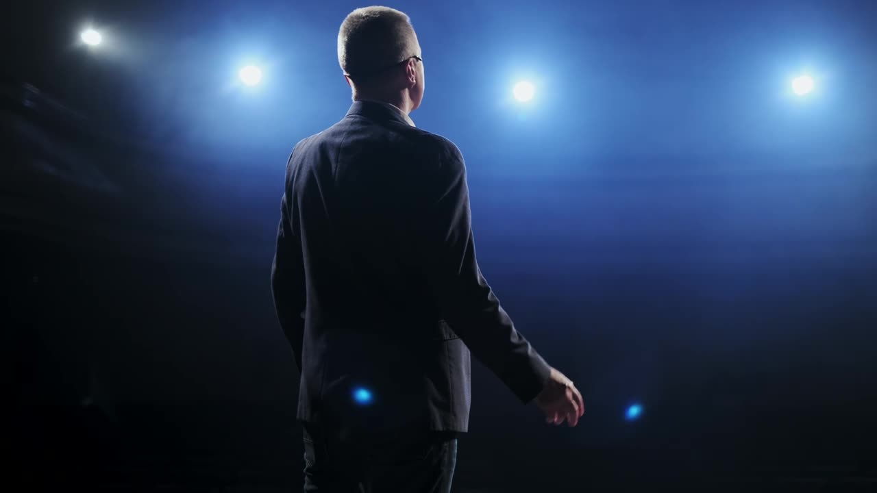 Free Video Stock Speaker In Suit Speaks To His Audience On Stage Live Wallpaper
