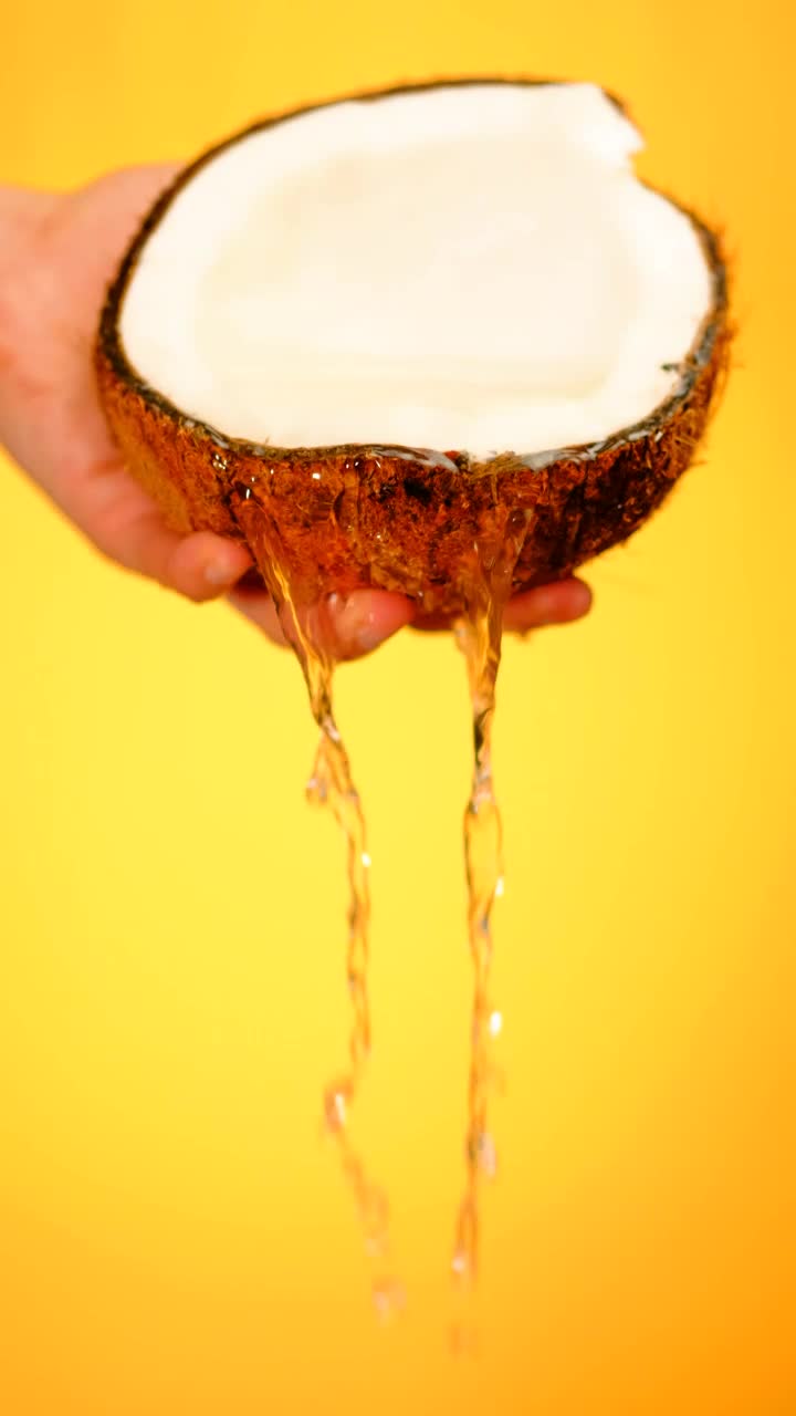 Free Video Stock Spilling Water From A Coconut On A Yellow Background Live Wallpaper