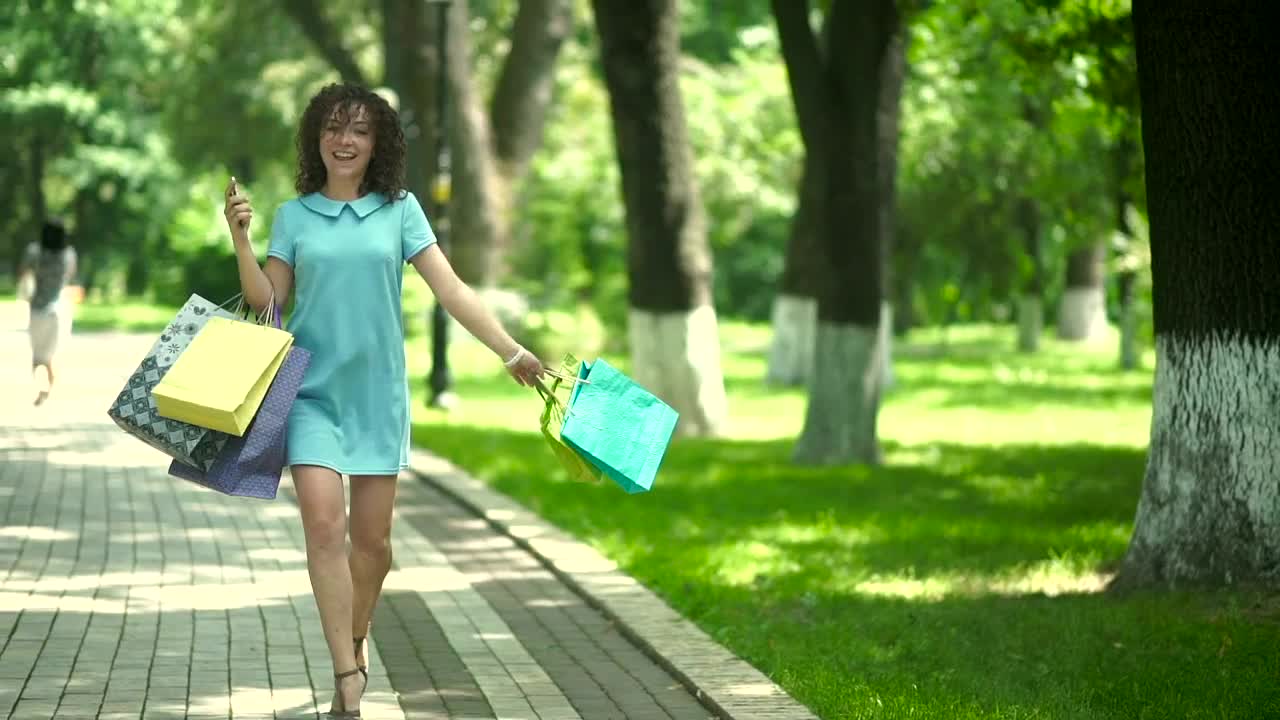 Free Video Stock Stylish Woman Spins With Shopping Bags On Sunny Parkway Live Wallpaper