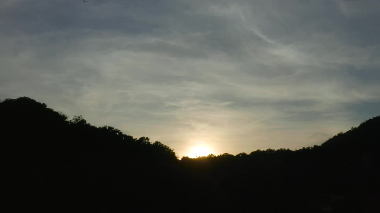 Free Video Stock sunset from the top of a rocky tree covered shoreline Live Wallpaper