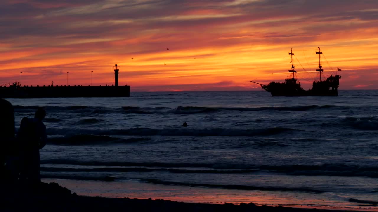 Free Video Stock sunset on a beach with people and a boat in Live Wallpaper