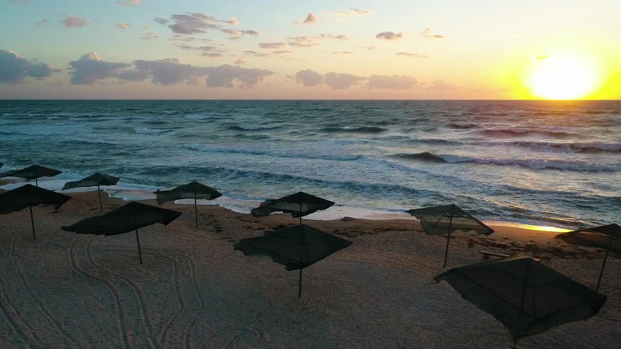 Free Video Stock sunset on a beach with wind and umbrellas Live Wallpaper