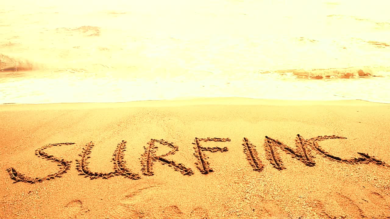 Free Video Stock surfing written in the sand on a sunny beach Live Wallpaper