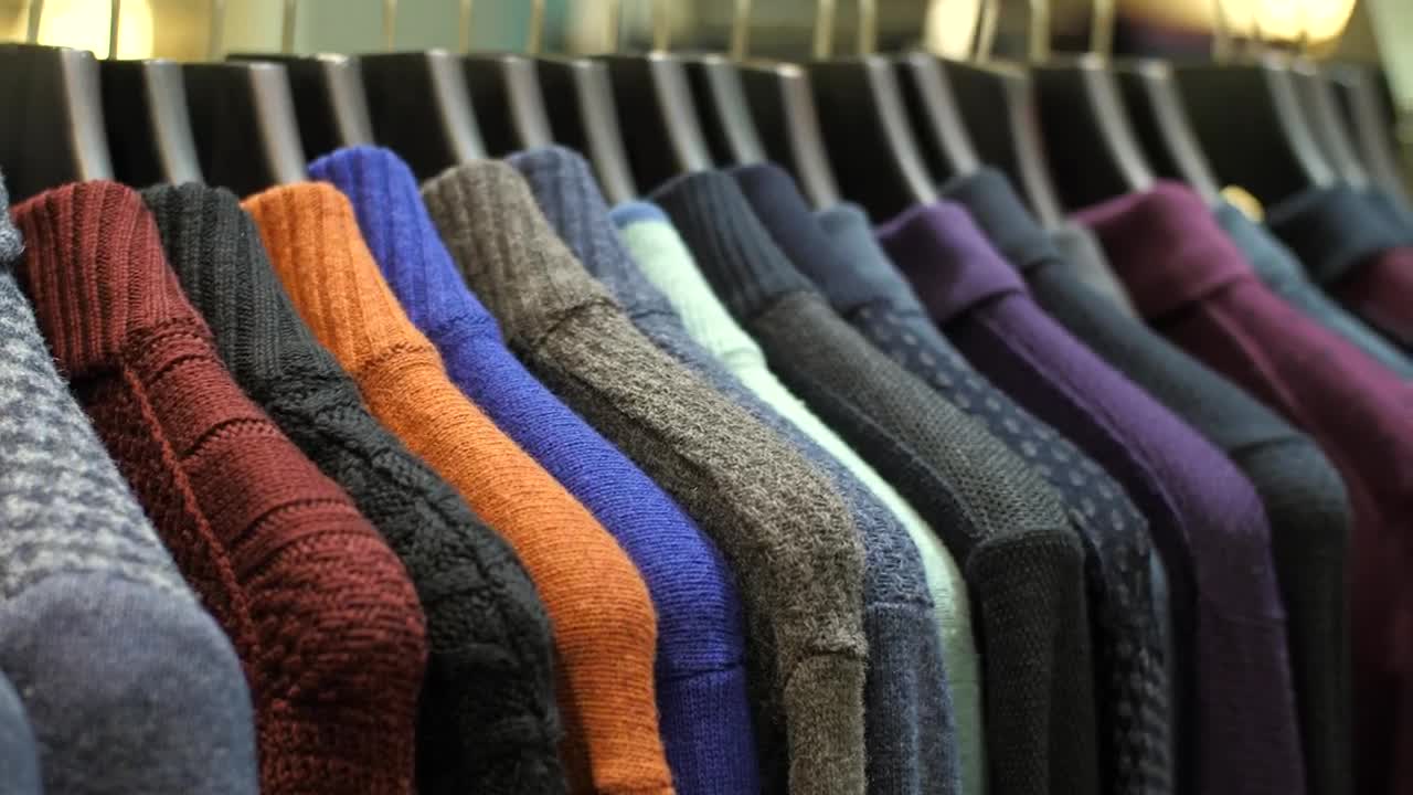 Free Video Stock sweaters hanging on the coat rack of a clothing store Live Wallpaper