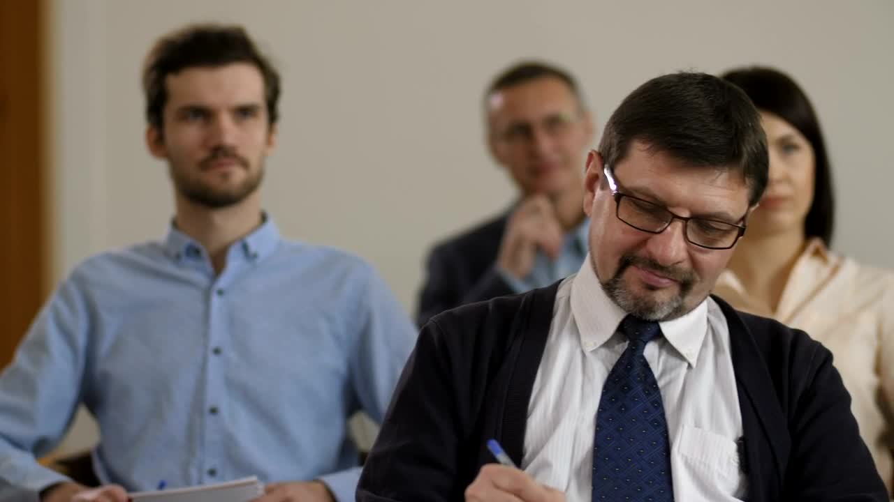 Free Video Stock taking notes while listening to a speaker Live Wallpaper