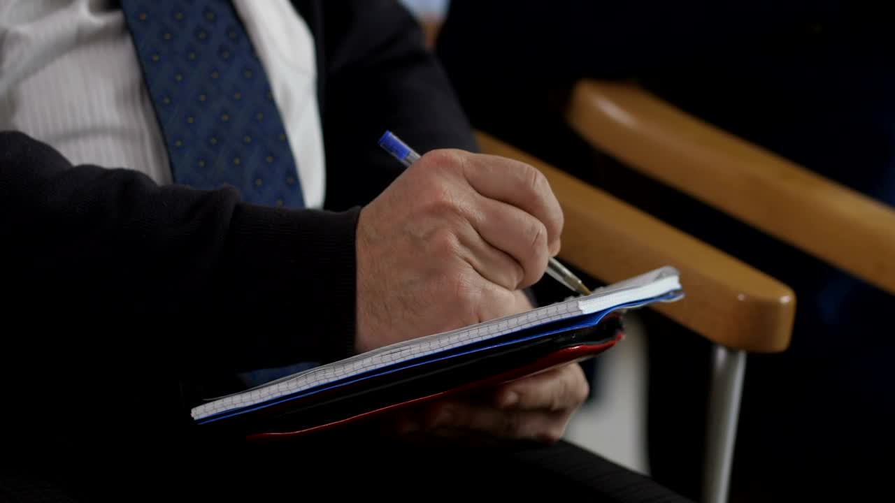 Free Video Stock taking notes with a pen during a seminar Live Wallpaper