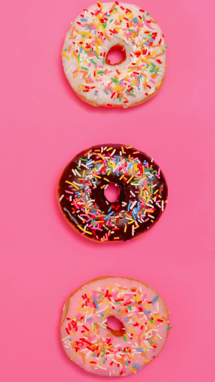 Free Video Stock taking three glazed donuts in a row on a pink Live Wallpaper