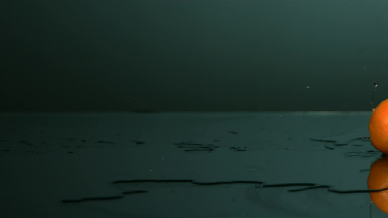 Free Video Stock tangerine rolling on a surface with water Live Wallpaper