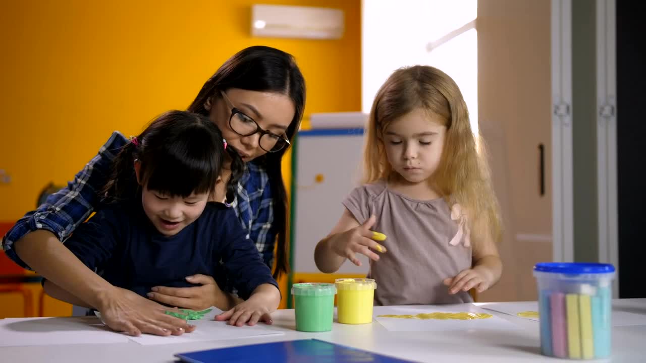 Free Video Stock teacher and girls painting with their hands Live Wallpaper